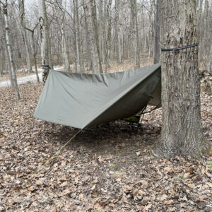 Rain tarp hanging between two trees in the woods